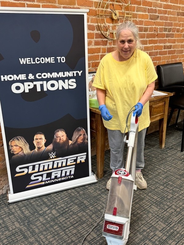 a woman using a vacuum cleaner at Home and Community Options