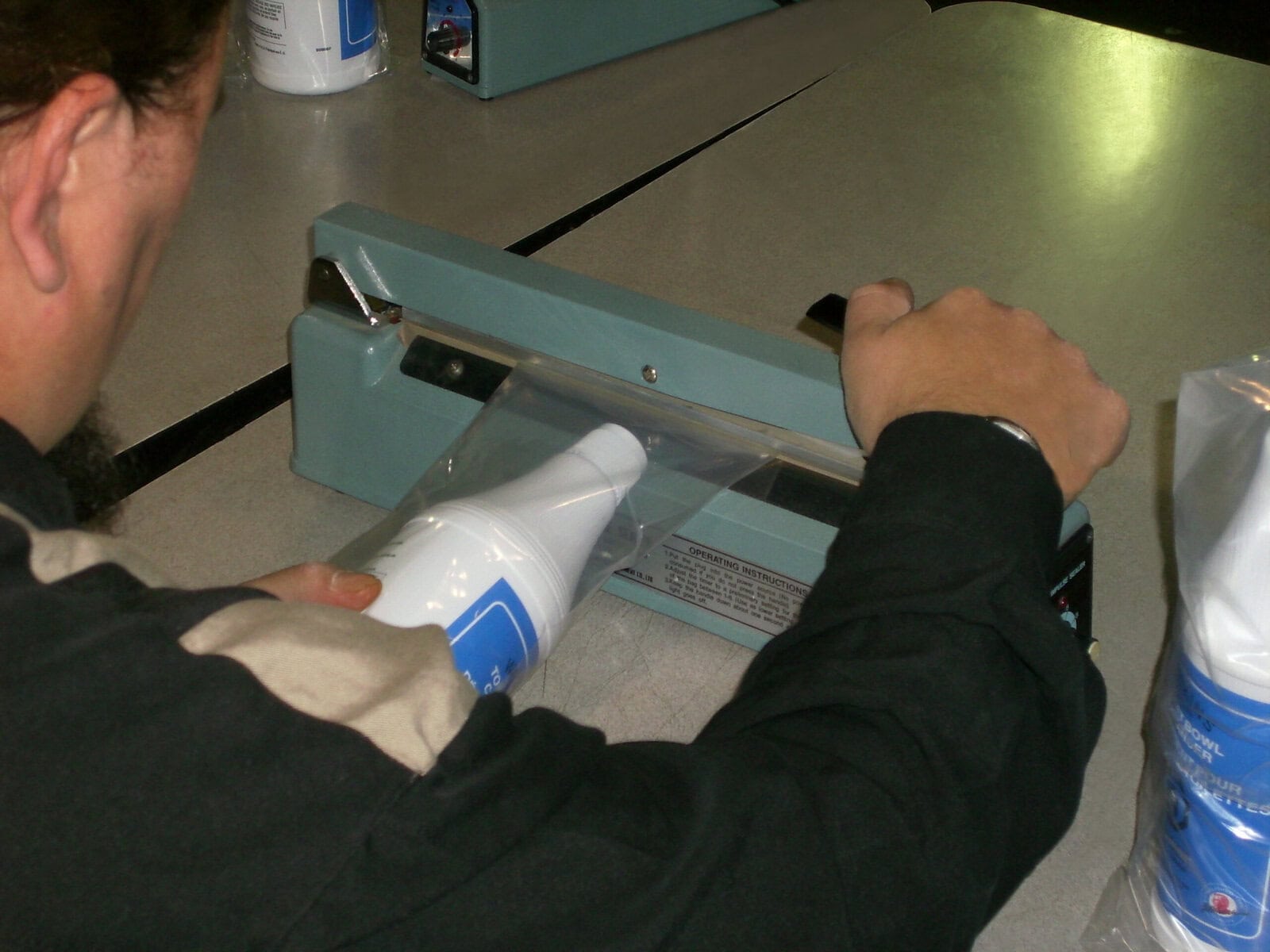 showing a close-up of a white plastic bottle getting sealed