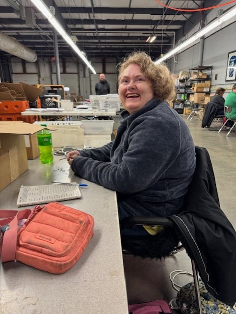 Taking a break for a big smile in the production area A woman taking a break from production work with a big smile