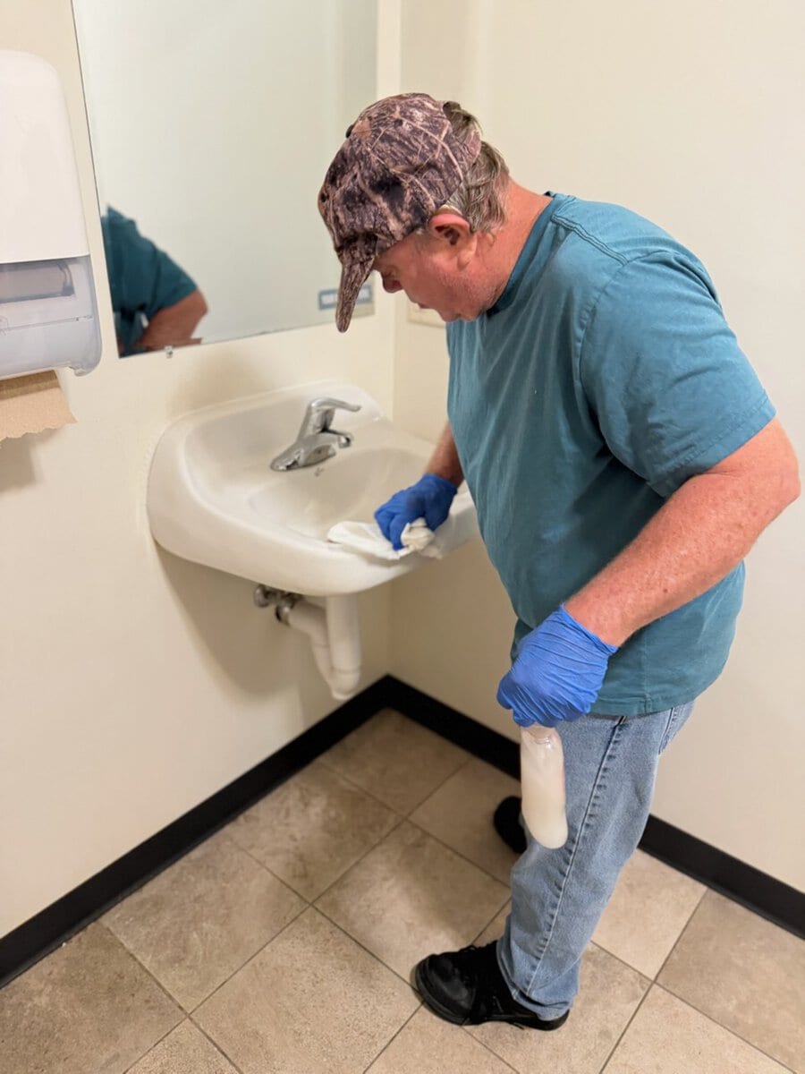 Man cleaning bathroom sink at RTP